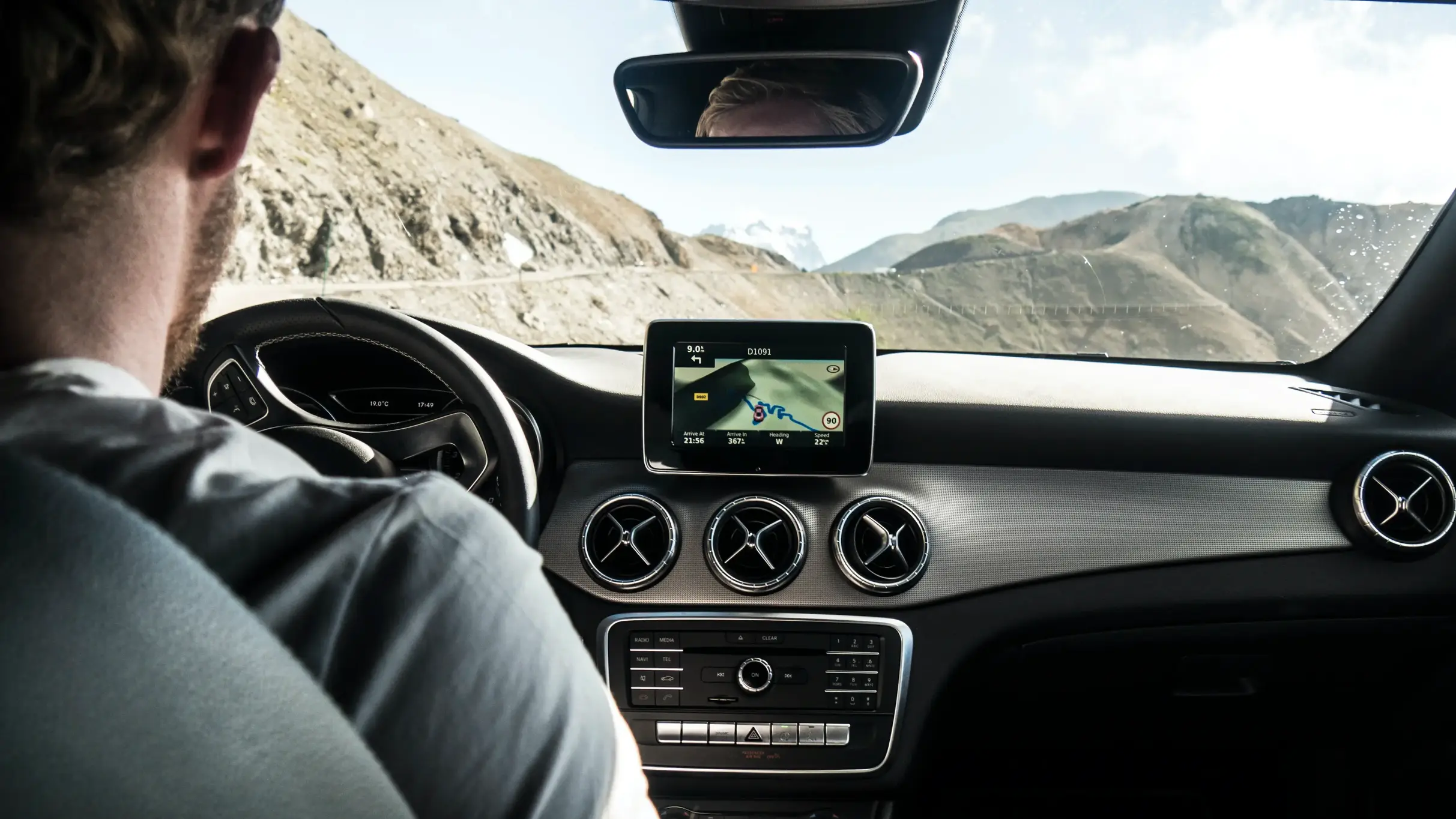 A behind shot of a man driving a car